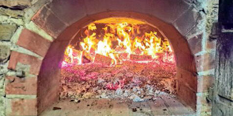 Die Glut im gemauerten Ofen erreicht bis zu 400 Grad, bevor die Brotlaibe ausgebacken werden können. (Foto: Christian Völkel)