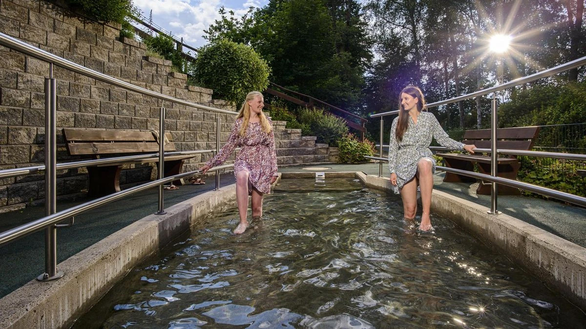 Melina Jabir und Melina Grebe setzten die Tipps des Referenten zum Wassertreten direkt im Tretbecken an der Espequelle in Bad Berleburg um. (© Stadt Bad Berleburg | Klaus-Peter Kappest)